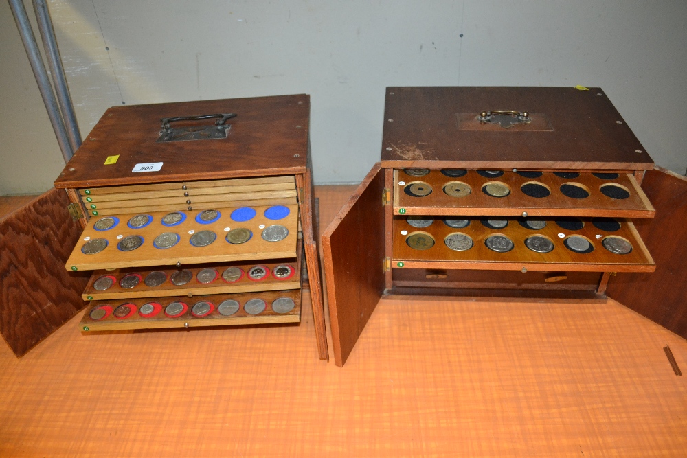 Two similar two door coin cabinets housing a collection of antique and later coinage