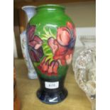 Moorcroft baluster form vase with floral tubeline decoration on a dark green ground,