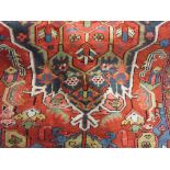 Small Heriz carpet with a typical lobed medallion design on a brick red field with borders,