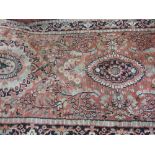 Pink ground Persian pattern runner with all-over floral decoration