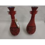 Pair of 20th Century red cinnabar baluster form vases decorated with birds in foliage,