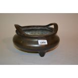 19th Century Chinese dark patinated bronze censer of squat circular design with shaped handles on