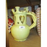 Large cream glazed pottery puzzle jug with pierced heart decoration and snake wound handle (a/f)