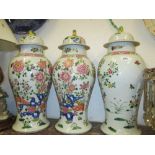 Garniture of three reproduction Canton famille rose style baluster form vases with covers