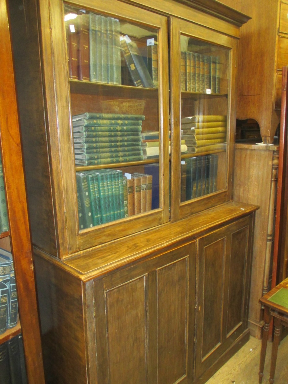 Large mid 20th Century oak bookcase having two glazed doors above two panelled doors on plinth base