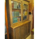 Large mid 20th Century oak bookcase having two glazed doors above two panelled doors on plinth base