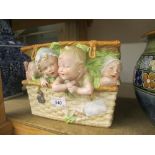 Late 19th or early 20th Century bisque porcelain box and cover in the form of four children in a