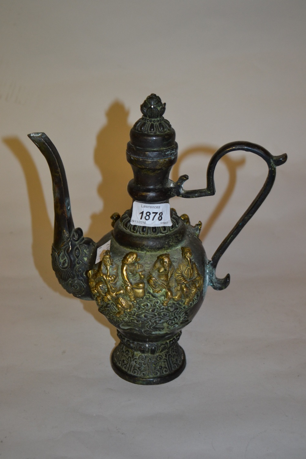 Chinese dark patinated and gilt bronze ewer decorated with figures in relief, 10,