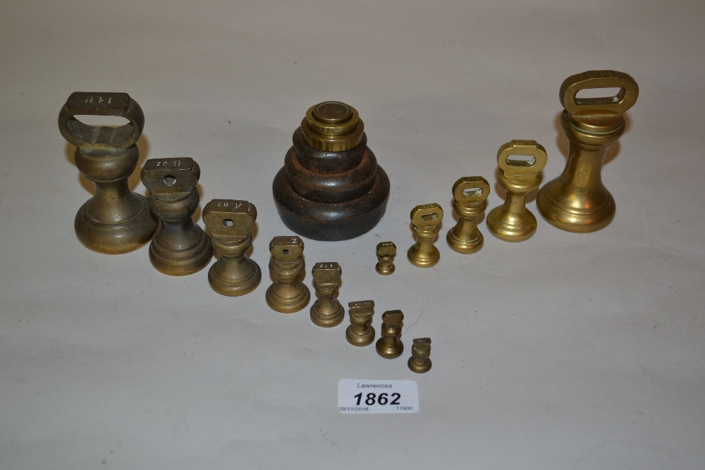 Two sets of brass bell form kitchen scale weights together with another set of kitchen weights