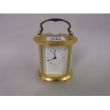 20th Century oval gilt brass cased carriage clock, the enamel dial with Roman numerals,