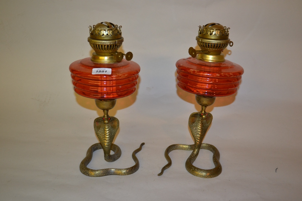 Pair of brass and ruby glass oil lamps,