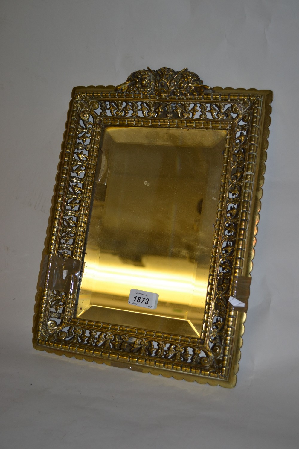 19th Century French pierced brass framed bevelled edge wall mirror with cherub mask head surmount,