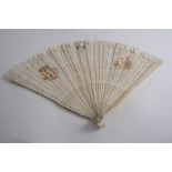 A 19TH CENTURY IVORY BRISE FAN with script initials & two painted vignettes on one side;  10"  (25.5