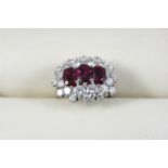 A RUBY AND DIAMOND CLUSTER RING the three oval-shaped rubies are set within a surround of twenty