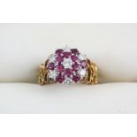 A RUBY AND DIAMOND CLUSTER RING the circular-cut diamonds and rubies are set to a gold openwork