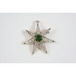 A DIAMOND AND DEMANTOID GARNET STAR BROOCH PENDANT centred with a circular demantoid garnet weighing