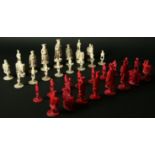 A CHINESE RED AND WHITE EAST AND WEST IVORY COMPOSITE CHESS SET white King 4ins. (10cms.) high