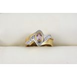 A PINK SAPPHIRE AND DIAMOND RING the 18ct. two colour gold mount is centred with an oval-shaped pink