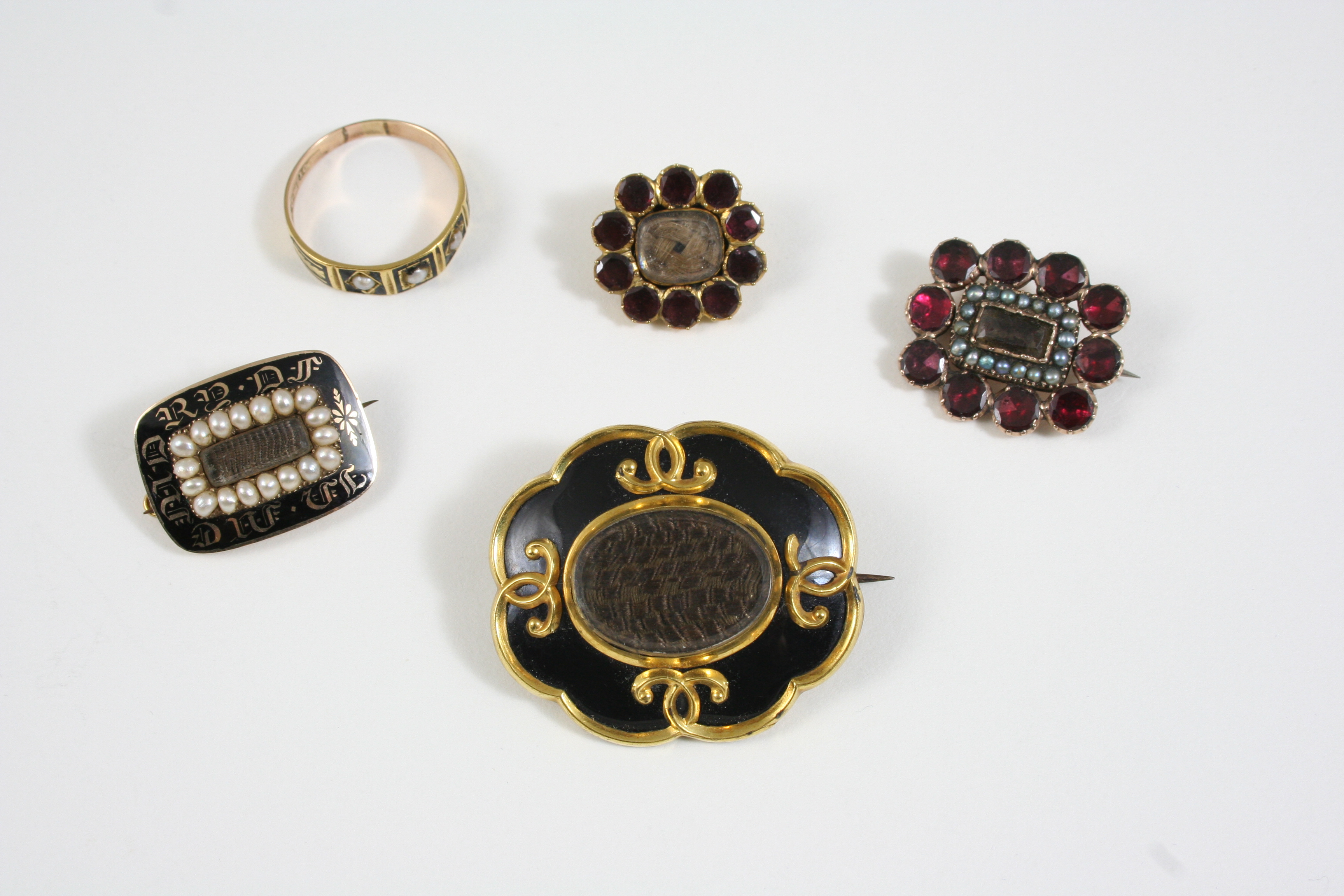 A GEORGIAN GOLD, PEARL  AND BLACK ENAMEL MOURNING BROOCH the centre section containing hair,