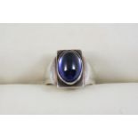 A SILVER RING BY GEORG JENSEN centred with an oval cabochon synthetic sapphire, with maker's mark to