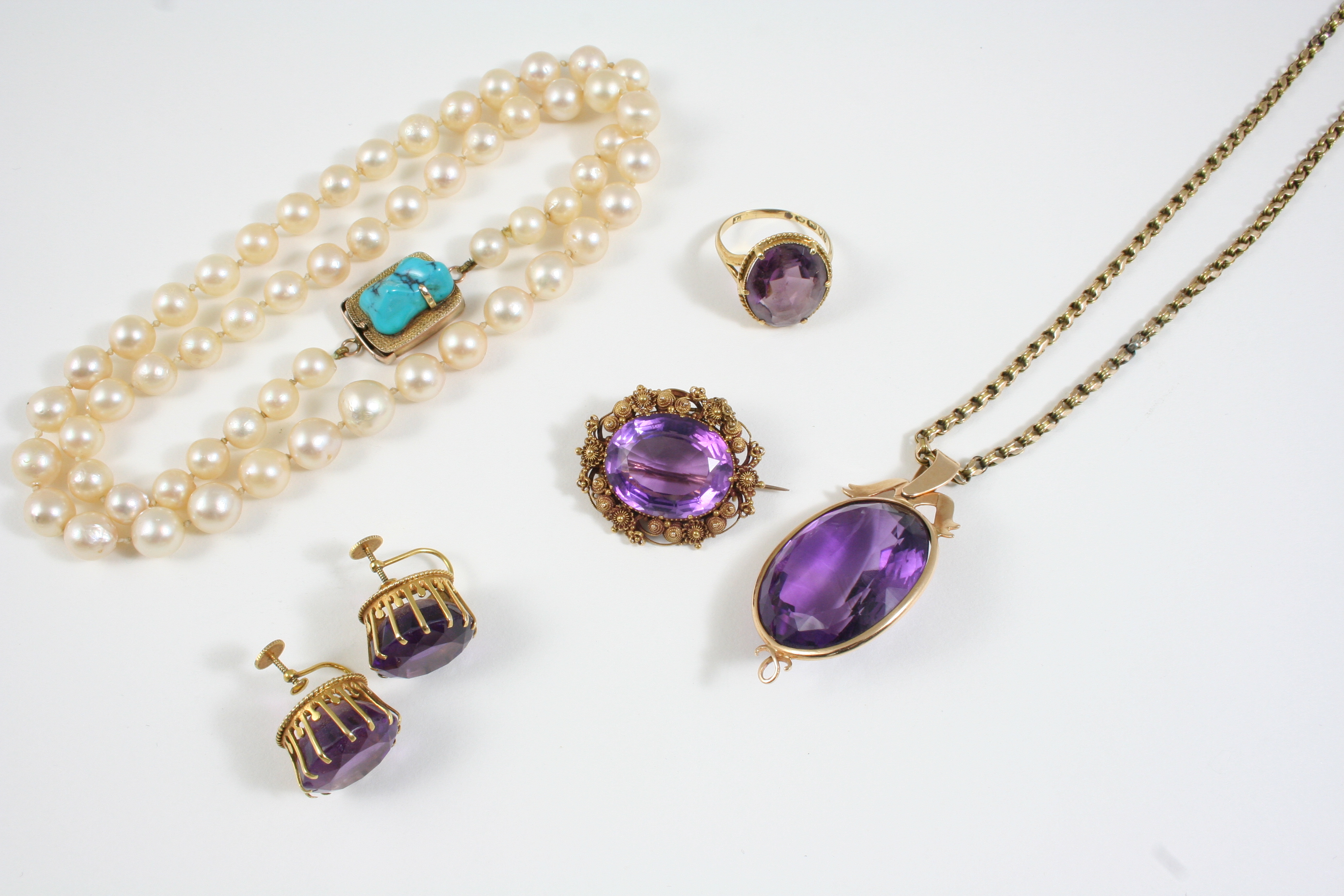 A QUANTITY OF JEWELLERY including an oval-shaped amethyst brooch, in a gold cannetille mount, an