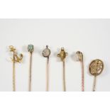 SIX ASSORTED GOLD AND GEM SET STICK PINS including a carved moonstone and rose-cut diamond one, a