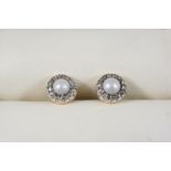 A PAIR OF CULTURED PEARL AND DIAMOND CLUSTER STUD EARRINGS each set with a cultured pearl within a