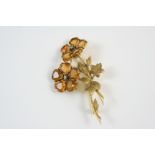 A CITRINE, DIAMOND AND GOLD BROOCH of floral form, each flower head is set with heart-shaped