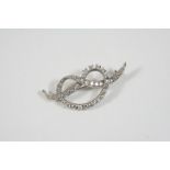 A DIAMOND BROOCH the knot design is set with slightly graduated circular-cut diamonds, 4.5cm. wide.