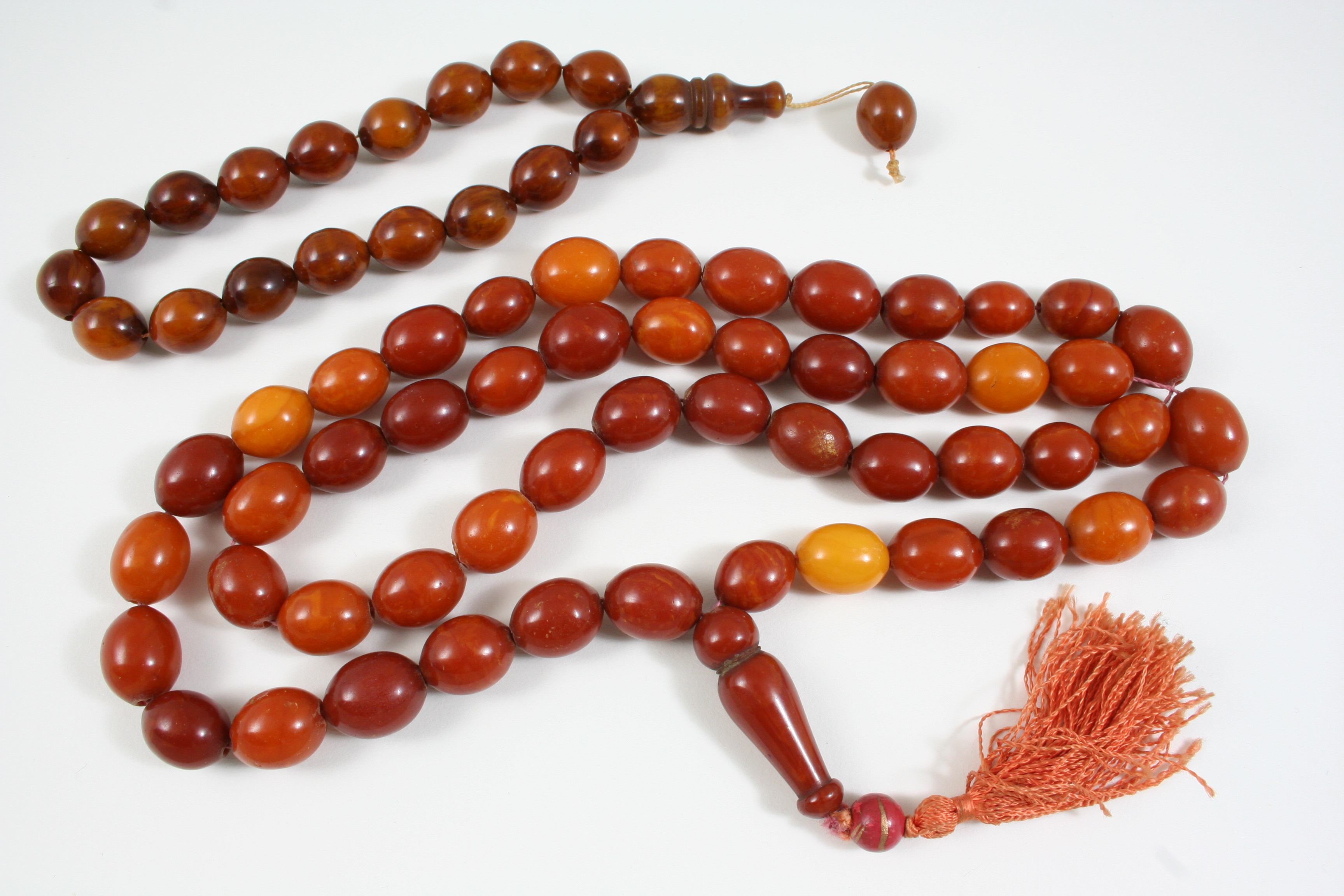 A SINGLE ROW AMBER BEAD NECKLACE 90cm. long, 99 grams, and an amber bead bracelet, 34 grams.