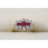 A RUBY AND DIAMOND CLUSTER RING centred with three rectangular-shaped rubies within a surround of