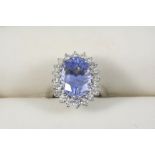 A SAPPHIRE AND DIAMOND CLUSTER RING BY MAUBOUSSIN, PARIS the oval-shaped sapphire is set within a