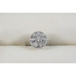 A DIAMOND CLUSTER RING the graduated circular-cut diamonds weigh approximately 0.70 carats in