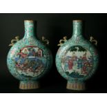 A PAIR OF FAMILLE ROSE CANTONESE VASE of pilgrim shape, one side painted with a roundel of court