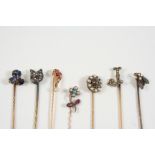 SEVEN ASSORTED GOLD AND GEM SET STICK PINS including one formed as a question mark and set with