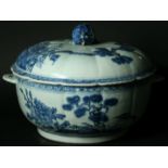 A BLUE AND WHITE TUREEN AND COVER of slightly lobed circular form, painted with fenced flowering