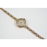A LADY'S GOLD, ENAMEL AND GEM SET WRISTWATCH the circular dial with Arabic numerals, the bezel