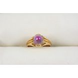 A GOLD RING set with a cabochon bi-colour star corundum. Size I 1/2.