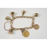 A 9CT. GOLD CHARM BRACELET set with assorted charms, 32 grams.