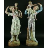 A PAIR OF FRENCH PORCELAIN FIGURES, late 19th century, modelled as couple holding up children, in