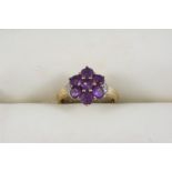 AN AMETHYST AND DIAMOND RING the seven circular-cut amethysts are set with a small diamond to each