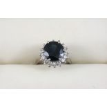 A SAPPHIRE AND DIAMOND CLUSTER RING the circular-cut sapphire is set within a surround of circular-