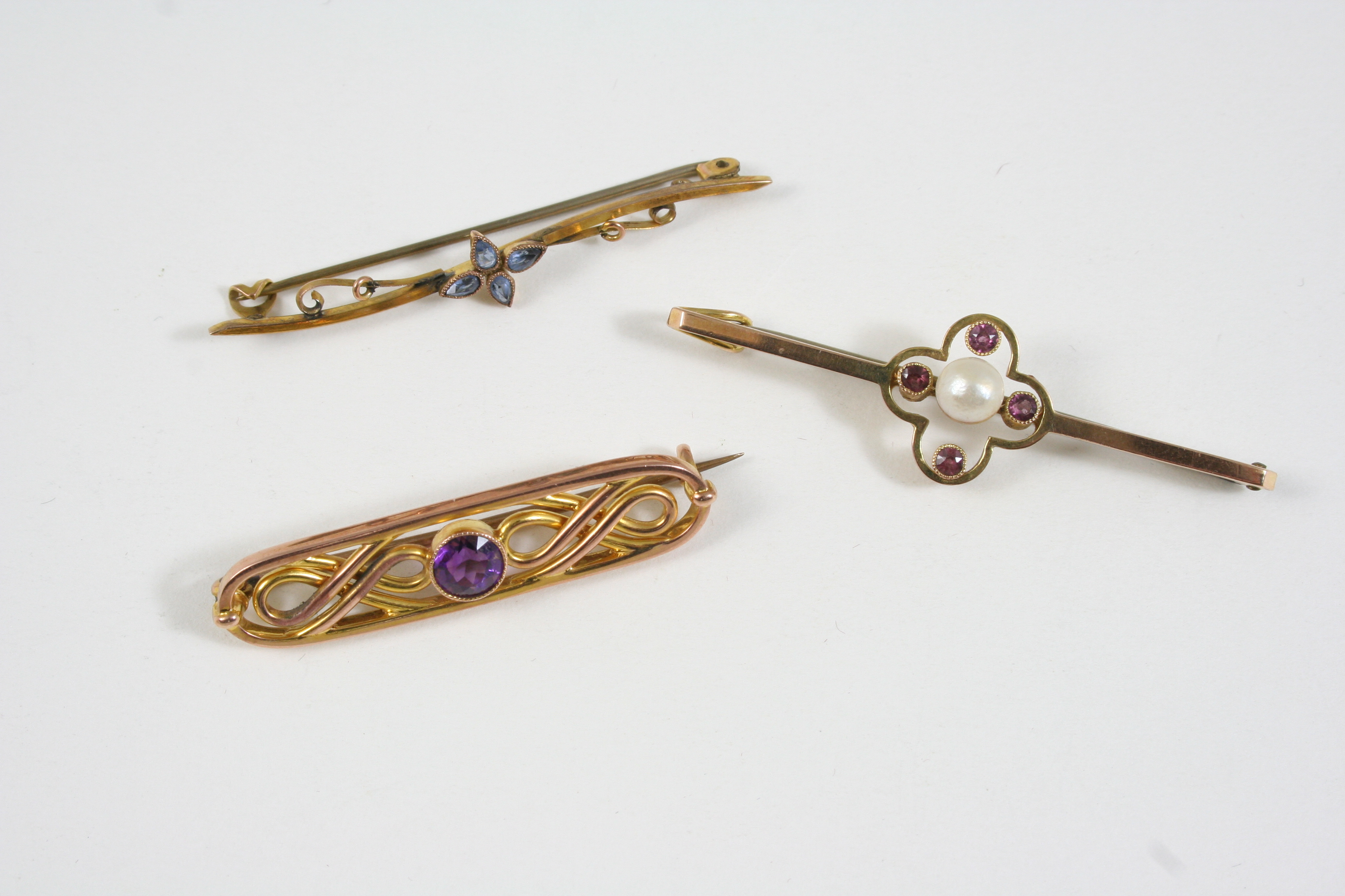 AN AMETHYST AND GOLD BROOCH the openwork design is centred with a circular-cut amethyst, 4cm.