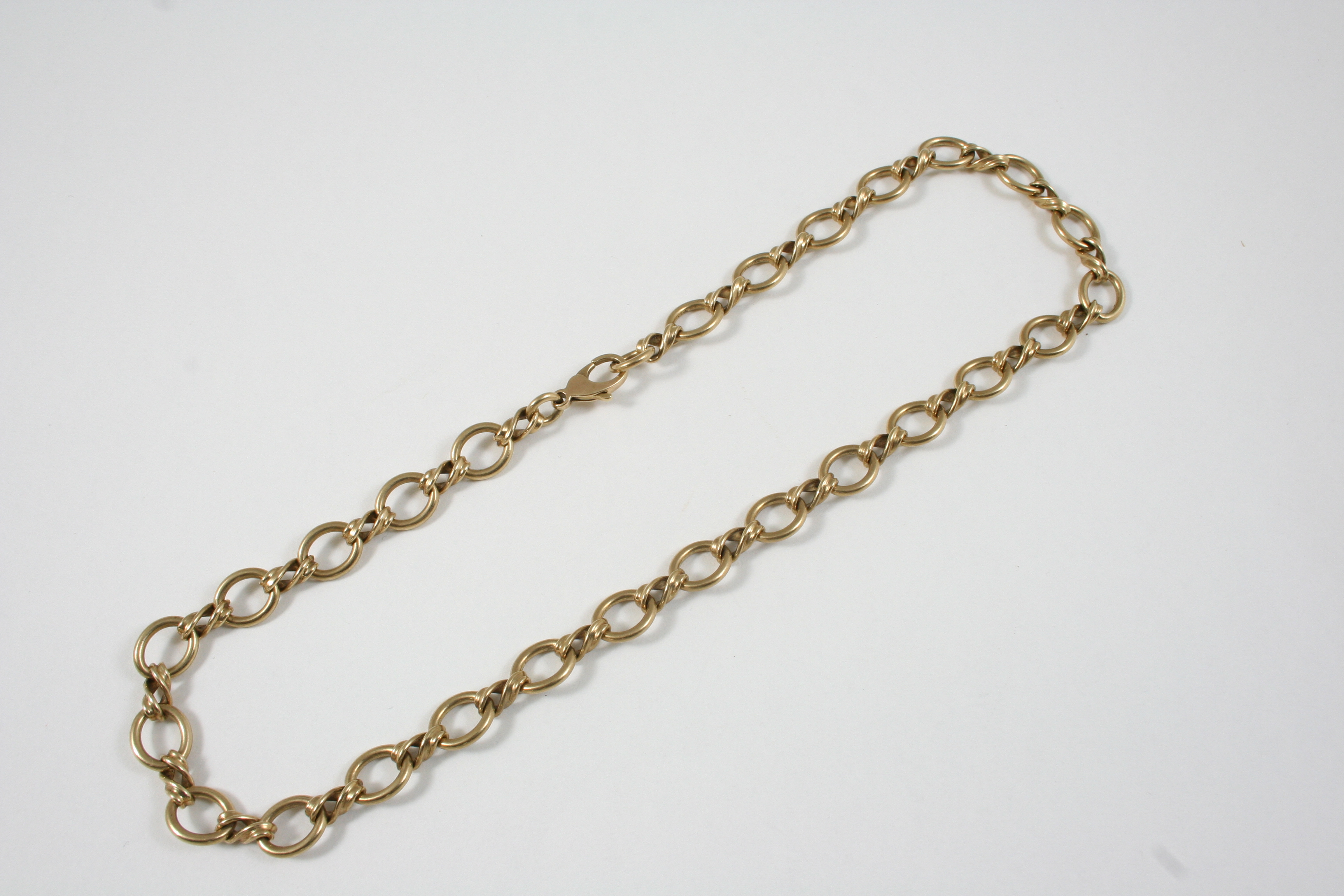 A 9CT. GOLD NECKLET formed with oval-shaped links, 41cm. long, 33 grams.