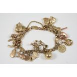 A 9CT. GOLD CHARM BRACELET set with assorted gold charms, 35 grams.