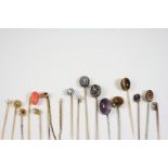 SIXTEEN ASSORTED GOLD AND GEM SET STICK PINS including a blue enamel one set with rose-cut diamond