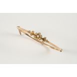 A VICTORIAN GOLD AND PEARL SET HALF HINGED BANGLE the floral design set with graduated small pearls.