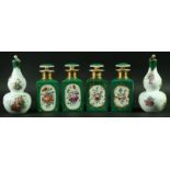 TWO PAIRS OF PARIS PORCELAIN SCENT BOTTLES AND STOPPERS with painted floral sprays on an apple green