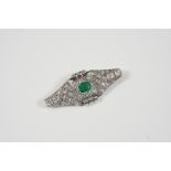 AN ART DECO EMERALD AND DIAMOND BROOCH the central emerald is set within a surround of graduated