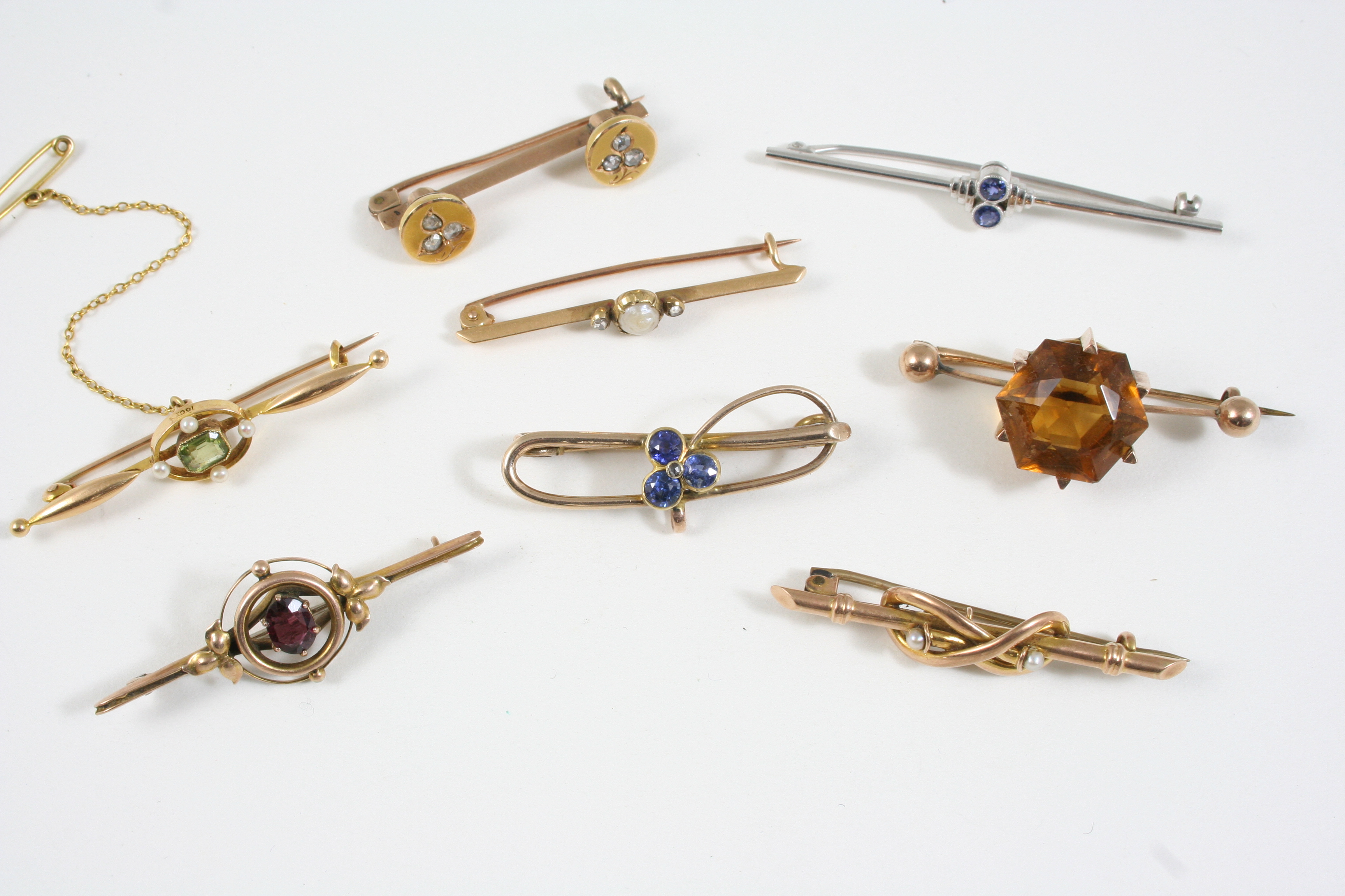 EIGHT ASSORTED GOLD AND GEM SET BROOCHES including a white gold one set with two circular-cut